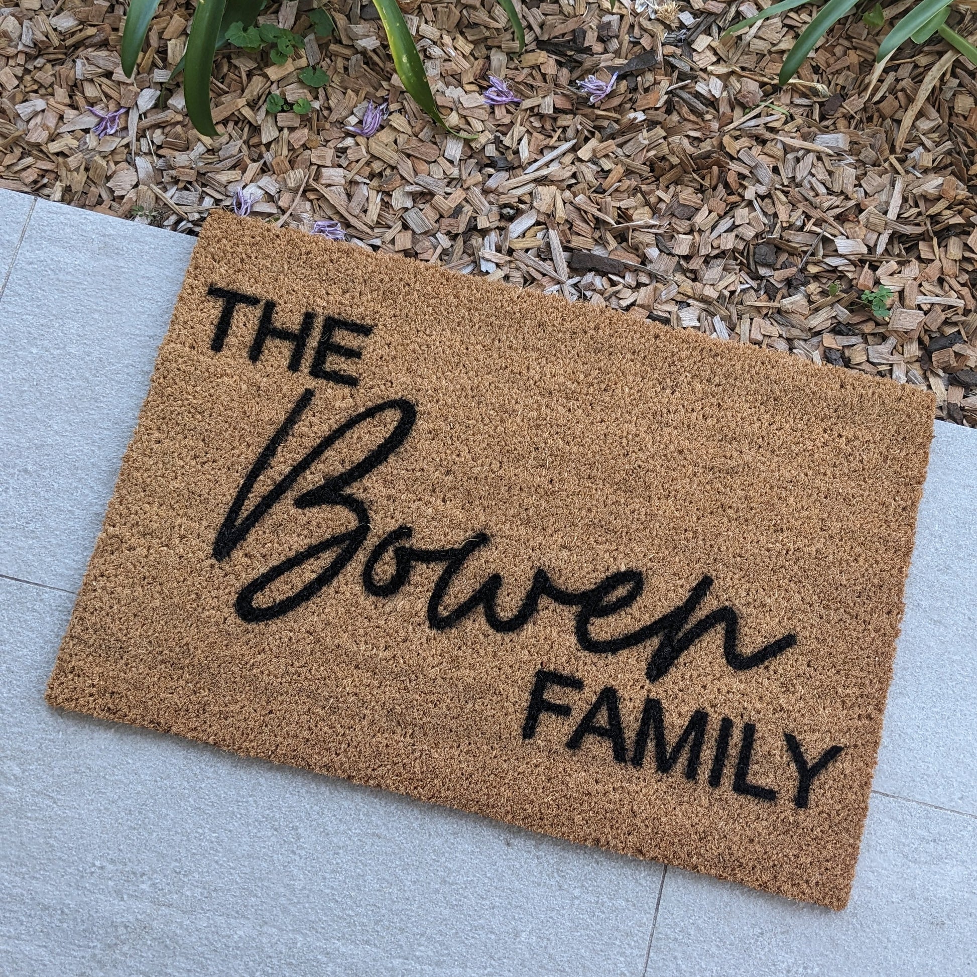 Custom Doormat with 'The Bowen Family' text on a patio